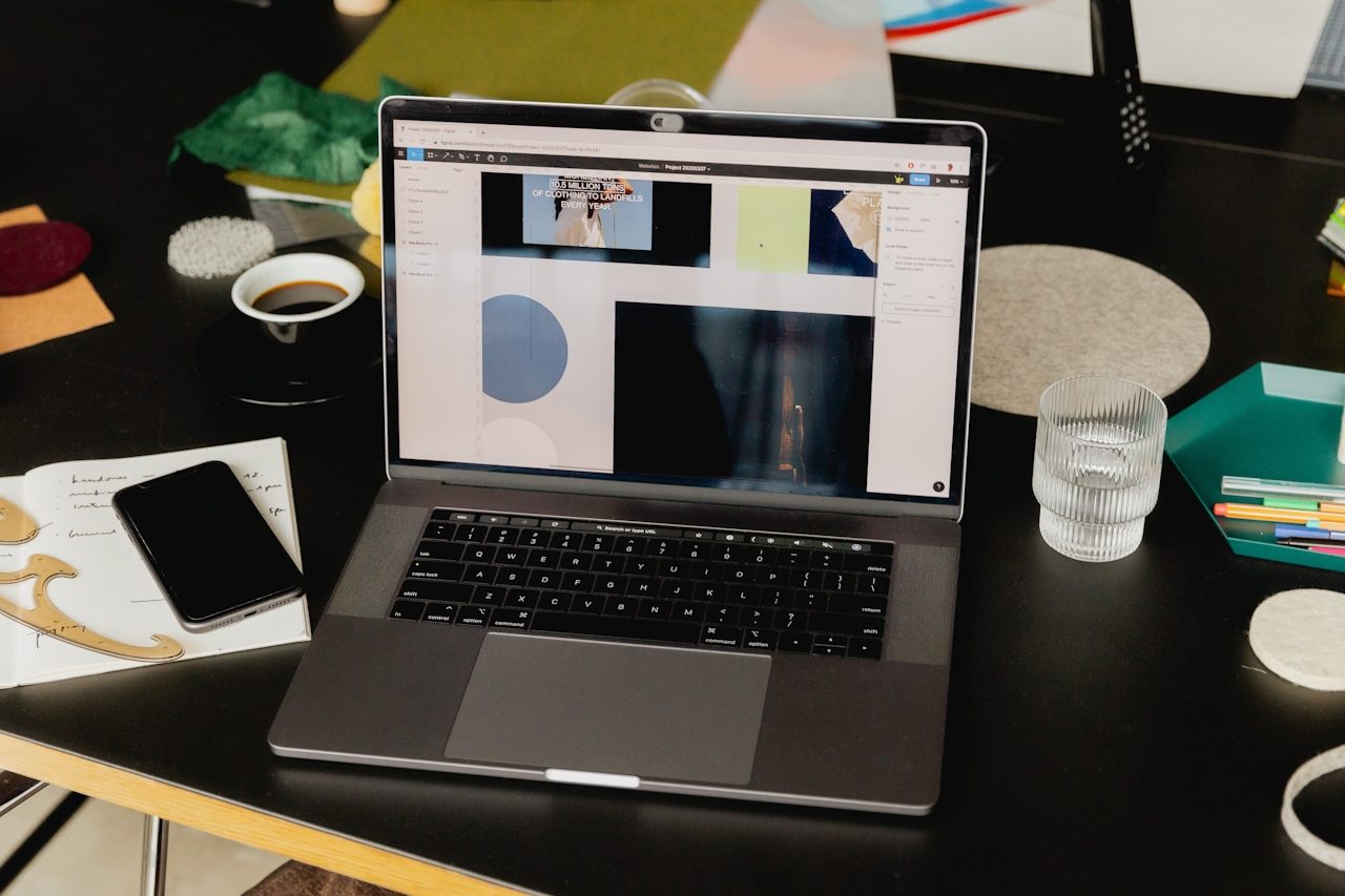 A marketing operations workspace with laptop, plans, and reporting materials