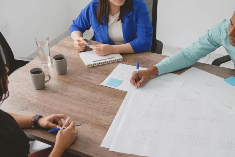 A facilitated planning conversation around a table with notes and coffee