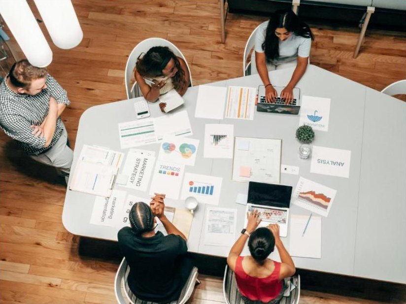 A team working through marketing strategy documents and analysis around a table